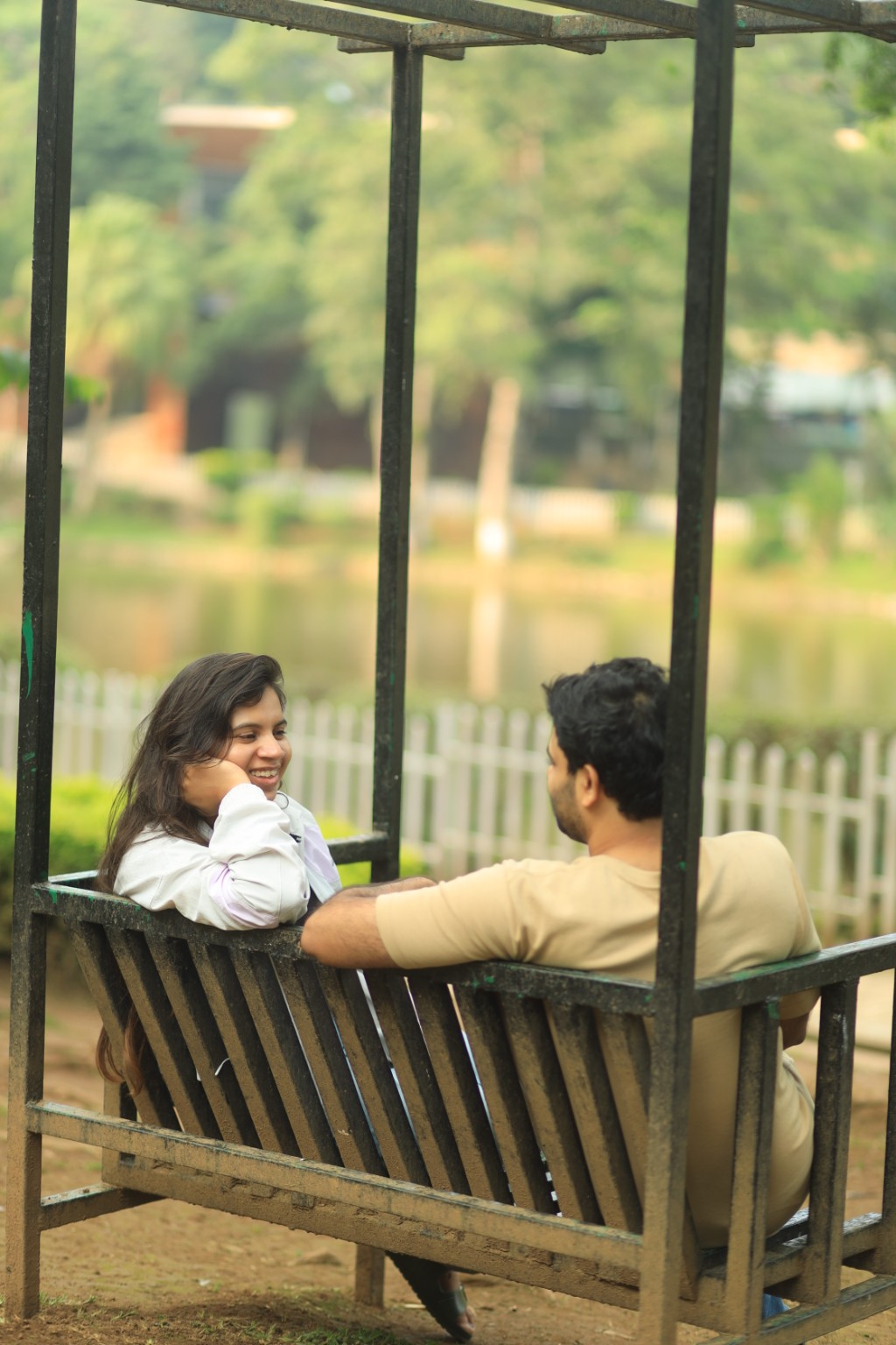 Snigdha and Somnath having a conversation together on a garden swing